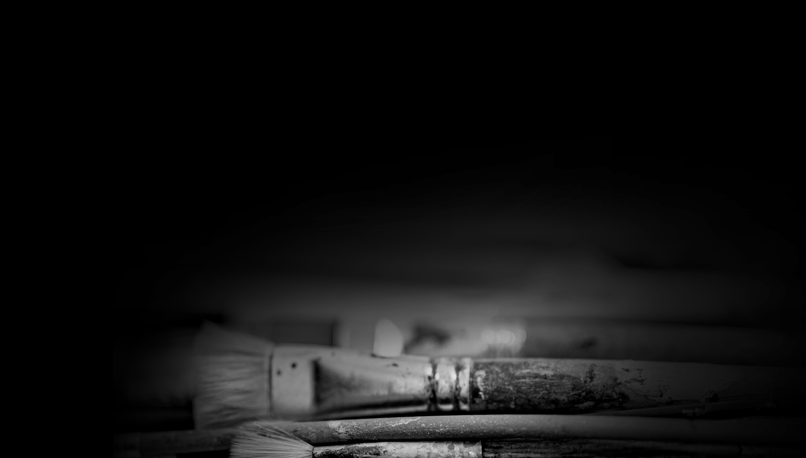 Schwarz Weiß Bild mit liegenden Pinseln im Bildvordergrund - Ulrike Schwier Kommunikationsdesign.